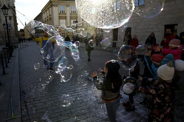 A child plays with soap bubbles at the Old Town in Krakow, Poland January 30, 2016. (Photo by Kacper Pempel/Reuters)