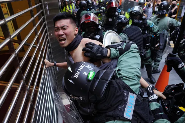 A protester is detained in Central district of Hong Kong on Monday, November 11, 2019. A Hong Kong protester was shot by police Monday in a dramatic scene caught on video as demonstrators blocked train lines and roads during the morning commute. (Photo by Vincent Yu/AP Photo)