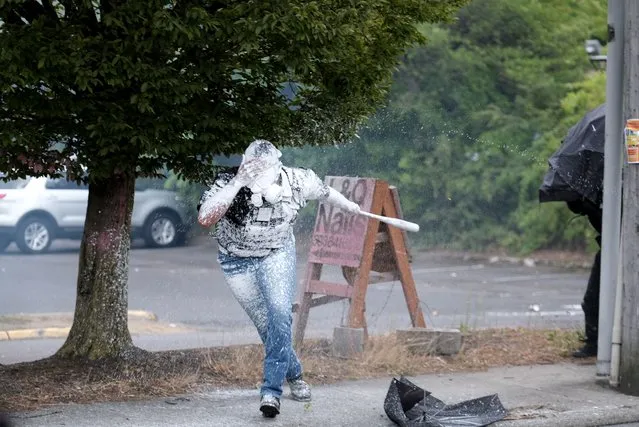 Tusitala “Tiny” Toese, a member of the far-right group Proud Boys, retreats after getting covered in paint by anti-fascist protesters during clashes between the politically opposed groups on Sunday, August 22, 2021, in Portland, Ore. (Photo by Alex Milan Tracy/AP Photo)