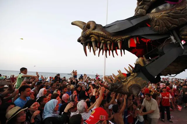 People play with a statue of a dragon during the Aoussou Carnival in Sousse, Tunisia July 26, 2015. (Photo by Anis Mili/Reuters)