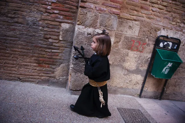 A child penitent of the “Silencio del Santisimo Cristo del Rebate” brotherhood takes part during a Holy Week procession in the Spanish village of Tarazona on April 11, 2017. Christian believers around the world mark the Holy Week of Easter in celebration of the crucifixion and resurrection of Jesus Christ. (Photo by Ander Gillenea/AFP Photo)