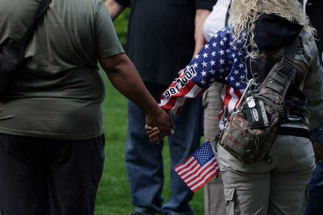 People hold hands as they attend a ceremony marking the 23rd anniversary of the September 11, 2001 attacks on the World Trade Center at the 9/11 Memorial and Museum in Manhattan, New York City on September 11, 2024. (Photo by Kent J.Edwards/Reuters)