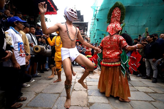 Masked dancers perform a ritualistic dance at Kathmandu Durbar Square during the procession of erecting a sacred pole locally called “Ya: Shi”, marking the formal start of Indra Jatra dedicated to rain god Indra in Kathmandu, Nepal, on September 15, 2024. The festival lasts for eight days with singing, mask dancing, and other rituals. Indra Jatra festival falls on the fourth day of the waxing moon in the month of Bhadra as per the lunar calendar. Legends say that the Indra Jatra festival observes the victory of the gods over the demons to release Jayanta, the son of Lord Indra. Indra, the god of rain, is worshiped in this festival primarily celebrated by the Newar communities following both Hinduism and Buddhism. (Photo by Subaas Shrestha/NurPhoto/Rex Features/Shutterstock)