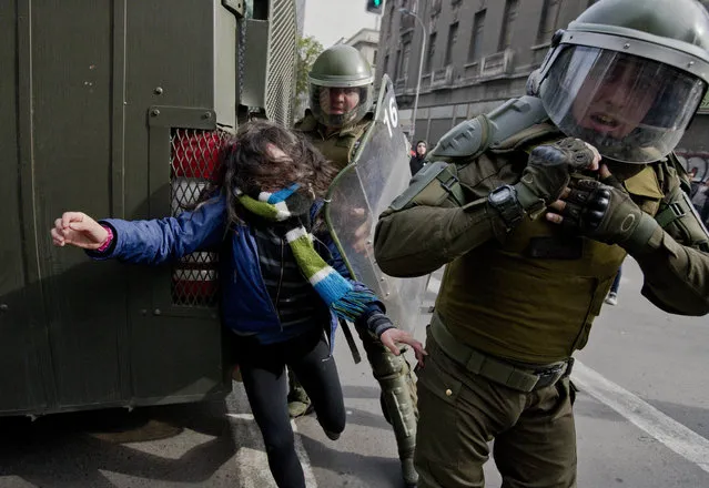 A high school student is detained by police during a march in downtown Santiago, Chile, Wednesday, June 15, 2016. Protesters are demanding education reform, such as free access to school for all ages, including university level. (Photo by Esteban Felix/AP Photo)