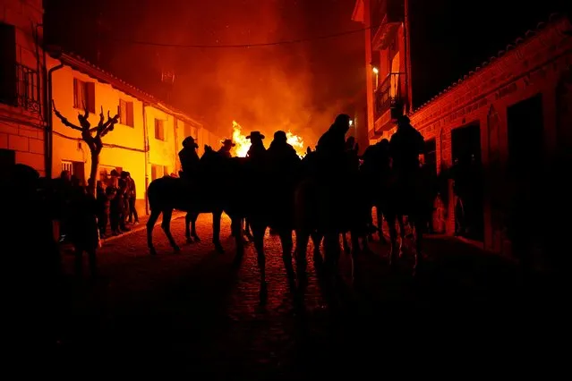 Riders wait for the start of the annual “Luminarias” celebration on the eve of Saint Anthony's day, Spain's patron saint of animals, in the village of San Bartolome de Pinares, northwest of Madrid, Spain, January 16, 2020. (Photo by Juan Medina/Reuters)