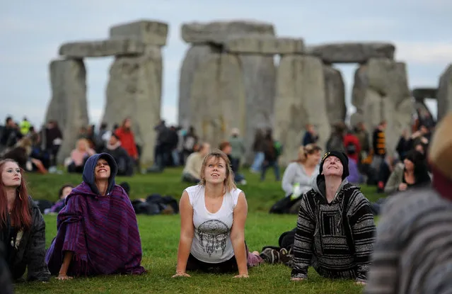 Today is also international yoga day – there are plenty of enthusiasts at Stonehenge. (Photo by Andrew Matthews/PA Wire)