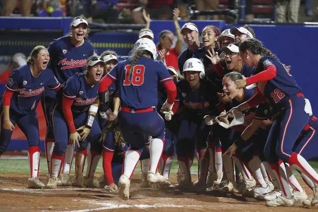 Arizona catcher Sharlize Palacios (18) is met at home plate after a home run against Oklahoma State during the fifth inning of an NCAA softball Women's College World Series game Thursday, June 2, 2022, in Oklahoma City. (Photo by Alonzo Adams/AP Photo)