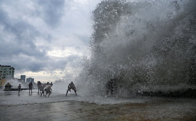 People enjoy the waves at the Malecon in Havana, on September 26, 2024, after the passage of hurricane Helene. Hurricane Helene strengthened to an "extremely dangerous" Category 4 storm as it barreled toward landfall on the Florida coast, US meteorologists said. (Photo by Yamil Lage/AFP Photo)