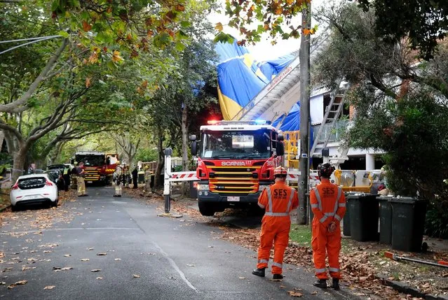 Police and rescue services work at the site of a hot air balloon accident in Elwood, Melbourne, Australia, 20 April 2022. The balloon was carrying 12 people when it made an emergency landing on a street in the Melbourne suburb of Elwood. There were no injuries reported, accoring to a statement from local police. (Photo by Luis Ascui/EPA/EFE)