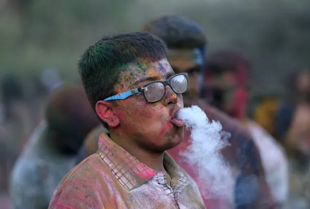 A Palestinian reveller smokes a cigarette as he takes part in a colours festival organized by Palestinian activists in the West Bank city of Ramallah August 20, 2015. (Photo by Mohamad Torokman/Reuters)