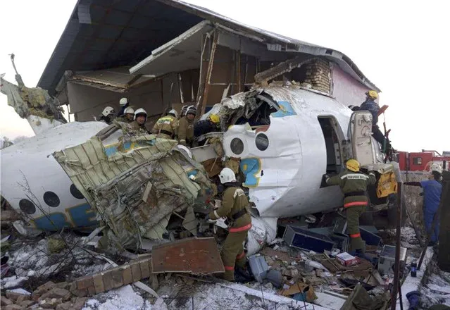 In this handout photo provided by the Emergency Situations Ministry of the Republic of Kazakhstan, police and rescuers work on the side of a plane crash near Almaty International Airport, outside Almaty, Kazakhstan, Friday, December 27, 2019. Almaty International Airport said a Bek Air plane crashed Friday in Kazakhstan shortly after takeoff causing numerous deaths. The aircraft had 100 passengers and crew onboard when hit a concrete fence and a two-story building shortly after takeoff. (Photo by Emergency Situations Ministry of the Republic of Kazakhstan Photo via AP Photo)