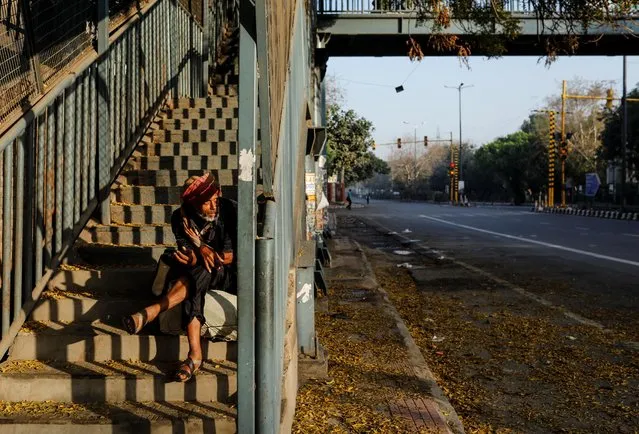 A homeless man sits on the stairs of a pedestrian bridge during 21-day nationwide lockdown to limit the spreading of coronavirus disease (COVID-19), in New Delhi, India, March 25, 2020. (Photo by Danish Siddiqui/Reuters)