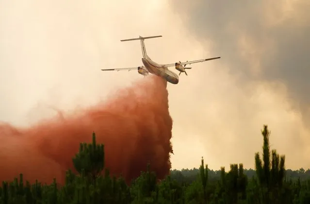 A firefighting plane drops flame retardant to extinguish a fire in Belin-Beliet, as wildfires continue to spread in the Gironde region of southwestern France on August 10, 2022. (Photo by Stephane Mahe/Reuters)