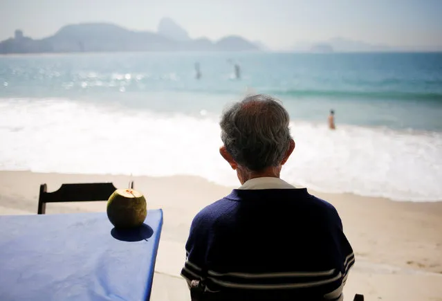 A man drinks coconut water on Copacabana beach in Rio de Janeiro, Brazil, May 2, 2016. (Photo by Nacho Doce/Reuters)