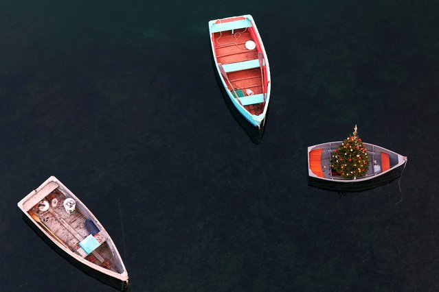 A drone view shows a Christmas tree in a dinghy in the waters off Marblehead, Massachusetts on December 7, 2024. (Photo by Brian Snyder/Reuters)