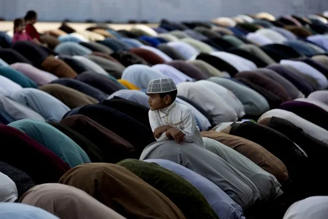 A Pakistani boy stands amid of people offer Friday prayers besides government's advice to avoid public gathering to avoid contracting coronavirus, at a local mosque in Rawalpindi, Pakistan, Pakistan, March 20, 2020. The vast majority of people recover from the new coronavirus. According to the World Health Organization, most people recover in about two to six weeks, depending on the severity of the illness. (Photo by B.K. Bangash/AP Photo)