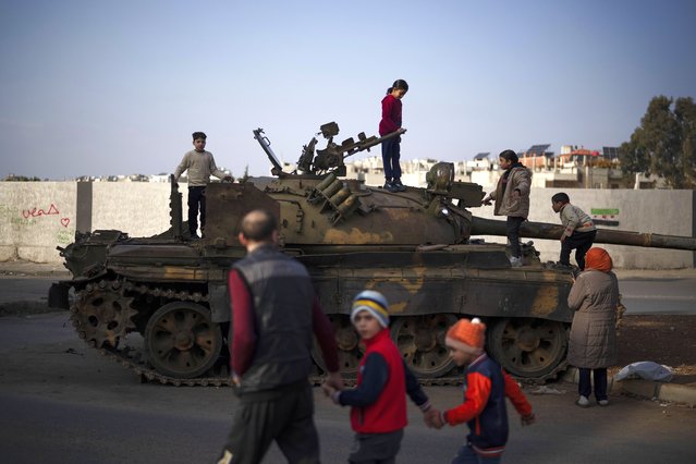 Children stand on the top of an abandoned Syrian government forces tank in the Alawite neighborhood of Homs, Syria, Thursday, December 26, 2024. (Photo by Leo Correa/AP Photo)