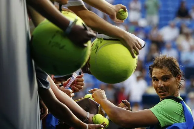 Rafael Nadal of Spain signs autographs for fans following his victory over Diego Schwartzman of Argentina during their second round match at the U.S. Open Championships tennis tournament in New York, September 2, 2015. (Photo by Shannon Stapleton/Reuters)