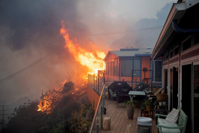 Plumes of smoke and fire rise as Palisades fire burns during a weather-driven windstorm on the west side of Los Angeles, on January 7, 2025. (Photo by Ringo Chiu/Reuters)