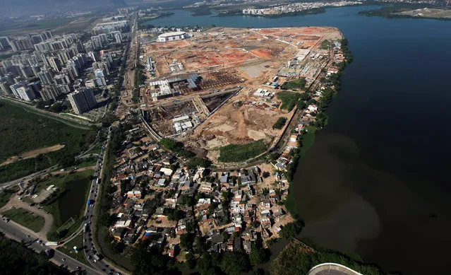An aerial view shows the Vila Autodromo slum (foreground) next to the 2016 Rio Olympic Park construction site in Rio de Janeiro, Brazil, June 27, 2014. Picture taken June 27, 2014. (Photo by Ricardo Moraes/Reuters)