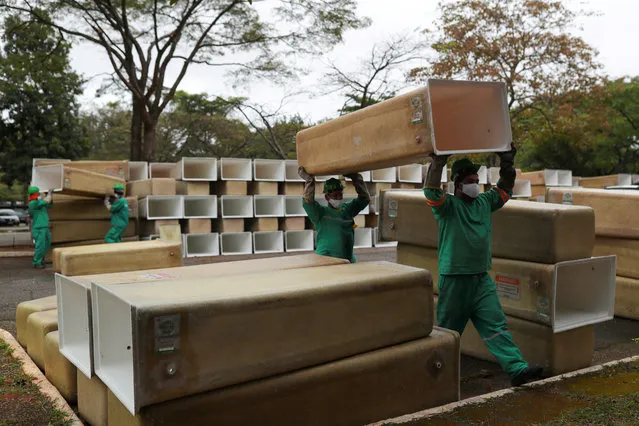 Men carry boxes to be installed for the coffins at the Sao Pedro municipal cemetery, amid the coronavirus disease (COVID-19) outbreak, in Sao Paulo, Brazil, May 14, 2020. (Photo by Amanda Perobelli/Reuters)