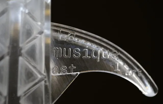 Details are seen as French engineer and professional violinist Laurent Bernadac poses with the “3Dvarius”, a 3D printed violin made of transparent resin, during an interview with Reuters in Paris, France, September 11, 2015. The words read “Music is art”. (Photo by Christian Hartmann/Reuters)