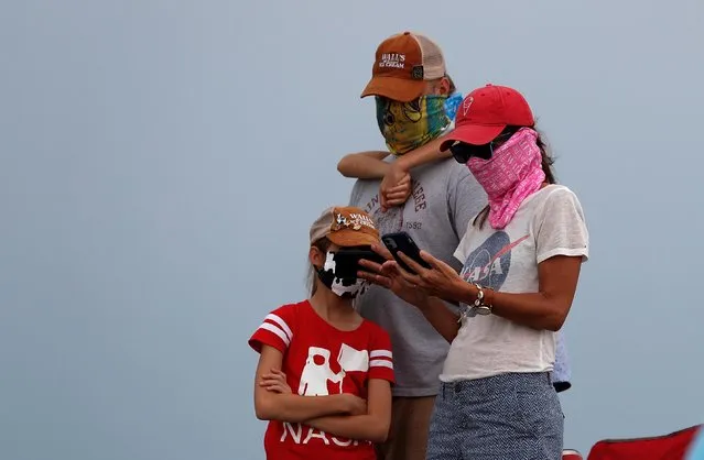 People wait to watch the launch of a SpaceX Falcon 9 rocket and Crew Dragon spacecraft carrying NASA astronauts Douglas Hurley and Robert Behnken during the NASA's SpaceX Demo-2 mission to the International Space Station from NASA's Kennedy Space Center before the launched was called off due to threatening weather conditions in Cape Canaveral, Florida, May 27, 2020. (Photo by Scott Audette/Reuters)