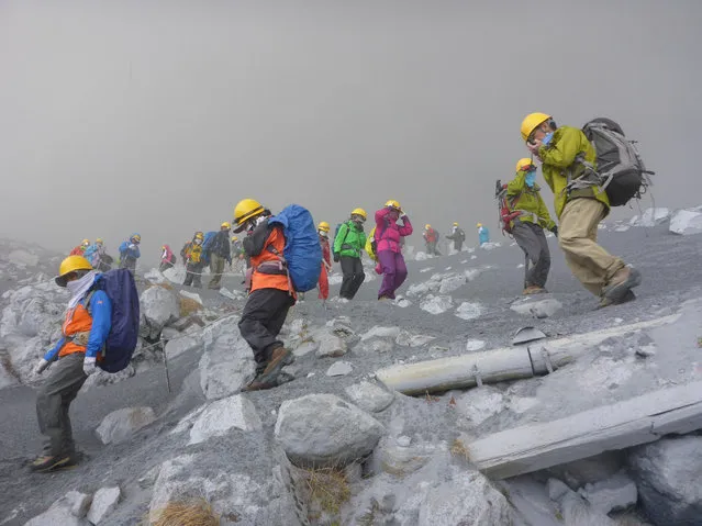 In this photo taken by an anonymous climber and was offered to Kyodo News, climbers descend Mt. Ontake to flee as the volcanic mountain erupts in central Japan, Saturday, September 27, 2014. (Photo by AP Photo/Kyodo News)