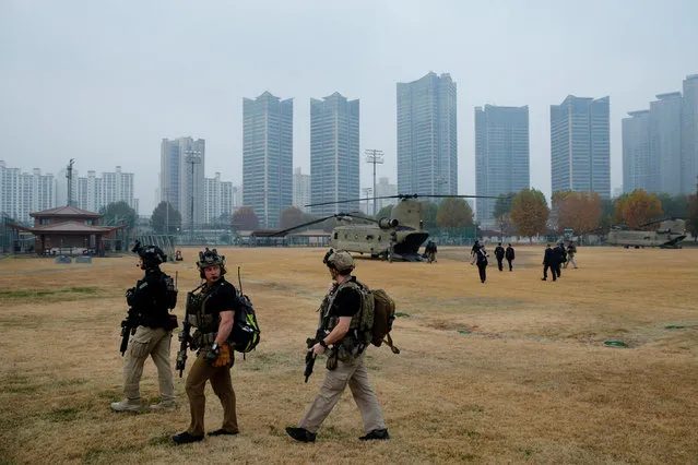 U.S. Secret Service counter-assault team members load up to travel by helicopter in the fog alongside President Trump's helicopter in a failed attempt to visit the Demilitarized Zone, outside Seoul, South Korea on November 8, 2017. (Photo by Jonathan Ernst/Reuters)