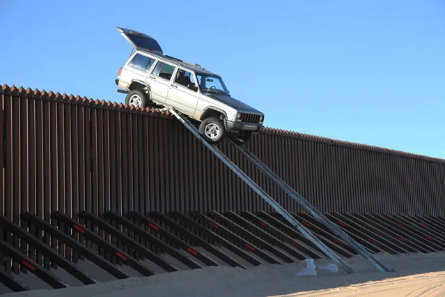 Suspected smugglers who tried to use ramps to drive an SUV over a 14-foot-tall border fence had to abandon their plan when the Jeep became stuck on top of the barrier, authorities said October 31, 2012. Agents patrolling the U.S.-Mexico border near the Imperial Sand Dunes in California’s southeast corner spotted the Jeep Cherokee teetering atop the fence early Tuesday, Border Patrol spokesman Spencer Tippets said. The vehicle was perched about five miles west of the Colorado River and the Arizona state line. Two smugglers on the Mexican side of the border were trying to free the Jeep when the agents approached, Tippets said. They ran further into Mexico and escaped. The Jeep was empty, but agents said it was probably filled with contraband like bales of marijuana before it got high-centered atop the fence. (Foto by AP Photo/U.S. Customs and Border Protection)