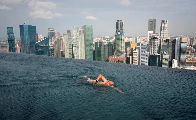 A guest swims in the infinity pool of the Skypark that tops the Marina Bay Sands hotel towers in Singapore June 24, 2010. (Photo by Vivek Prakash/Reuters)