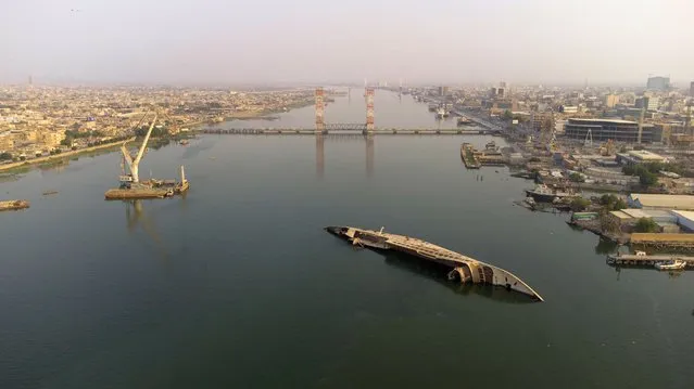 An aerial picture shows the capsized hull of "Al Mansur", the private yacht of toppled Iraqi President Saddam Hussein, in the Shatt al-Arab waterway, formed at the confluence of the Euphrates and Tigris rivers, in Iraq's southern city of Basra, on October 9, 2022. (Photo by Hussein Faleh/AFP Photo)
