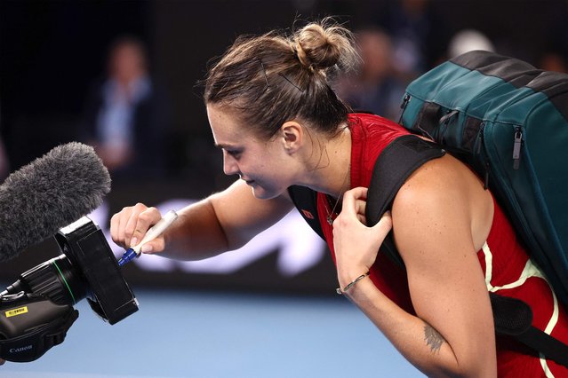 Belarus' Aryna Sabalenka writes a message on TV camera after a victory against USA's Coco Gauff during their women's singles semi-final match on day 12 of the Australian Open tennis tournament in Melbourne on January 25, 2024. (Photo by David Gray/AFP Photo)