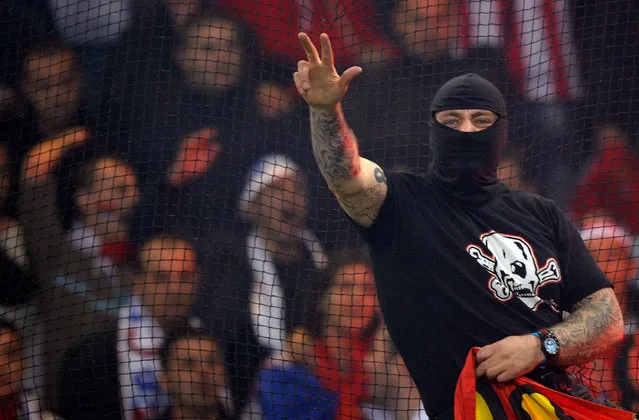 Balaclava clad Serbian fan Ivan Bogdanov gestures towards riot police during the UEFA Euro 2012 qualifying match between Italy and Serbia at Luigi Ferraris Stadium on October 12, 2010 in Genoa, Italy. (Photo by Claudio Villa/Getty Images)