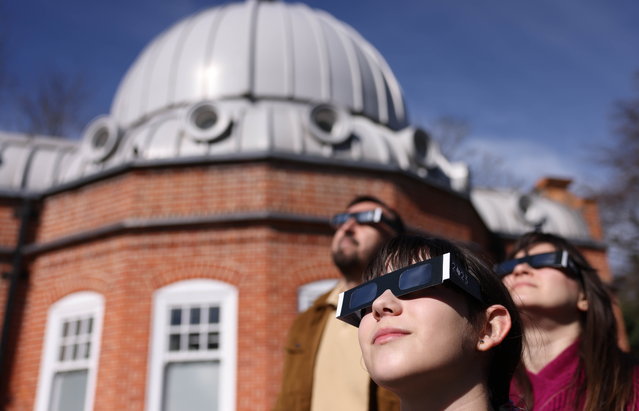People wear protective glasses during a partial solar eclipse, at the Royal Observatory Greenwich in London, Britain, 29 March 2025 (issued 01 April 2025). The meridian line in Greenwich represents the Prime Meridian of the world, Longitude Zero (0° 0' 0"). Every place on the Earth is measured in terms of its angle east or west from this line. Since 1884, the Prime Meridian has also served as the reference point for Greenwich Mean Time (GMT) which was distributed both nationally, via the Time Ball installed in 1833, and the national standardization for Railway Time in 1852. The year 2025 marks 350 years since the foundation of the Royal Observatory, the first state-funded, purpose-built scientific institution in Britain. It was founded in 1675 by British King Charles II to make astronomical observations that could help navigators at sea determine their longitude (east-west position). (Photo by Neil Hall/EPA)