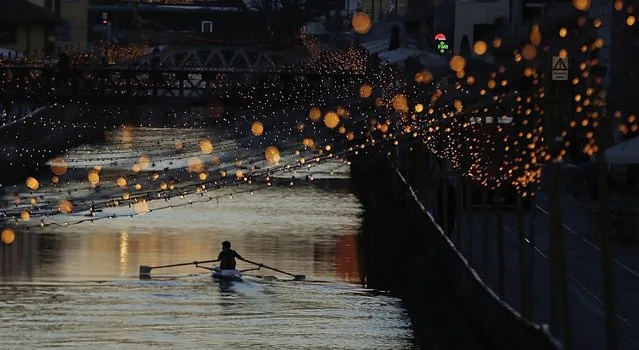 A rower paddles along the Naviglio canal decorated with Christmas lights in Milan, Italy, Monday, December 18, 2017. (Photo by Luca Bruno/AP Photo)