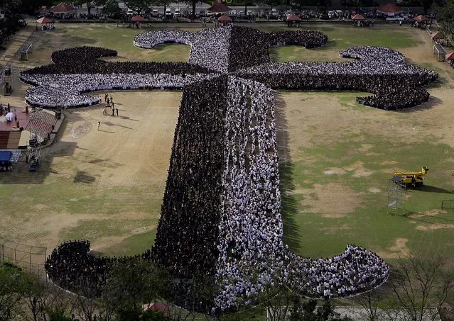 Filipino students, employees, administrators and seminarians from the University of Santo Tomas (UST) gather to form a “Dominican Cross” as they observe the start of Lent on Ash Wednesday, inside the UST campus in Manila. Organizers claimed to have more than 20,000 participants during the event and will attempt to the break the “Guinness World Record” as the “Largest Human Cross”. (Photo by Aaron Favila/Associated Press)