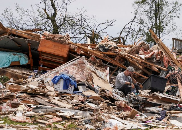 James Sexton holds his head in his hand as he sits among the debris of his destroyed home in the Sunshine Hills neighborhood after a series of tornadoes hit Laurel County, in London, Kentucky, U.S. May 18, 2025. (Photo by Seth Herald/Reuters)