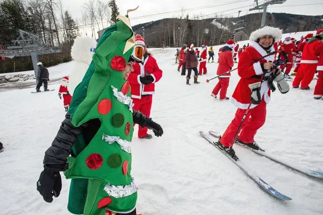 A person dressed as a Christmas Tree makes their way to a group photo during the “Santa Sunday” event at Sunday River Resort in Newry, Maine on December 11, 2022.  Money raised by the the event goes towards the River Fund Maine charity. (Photo by Joseph Prezioso/AFP Photo)
