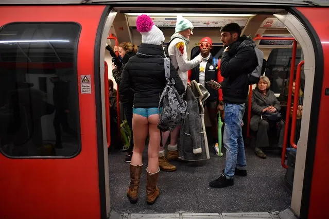 People take part in the annual “No Trousers On The Tube Day” (No Pants Subway Ride) at Liverpool Street Station in London on January 7, 2018. Started in 2002 with only seven participants, the day is now marked in over 60 cities around the world. The idea behind “No Pants” is that random passengers board a subway car at separate stops in the middle of winter, without wearing trousers. The participants wear all of the usual winter clothing on their top half such as hats, scarves and gloves and do not acknowledge each other's similar state of undress. (Photo by Ben Stansall/AFP Photo)