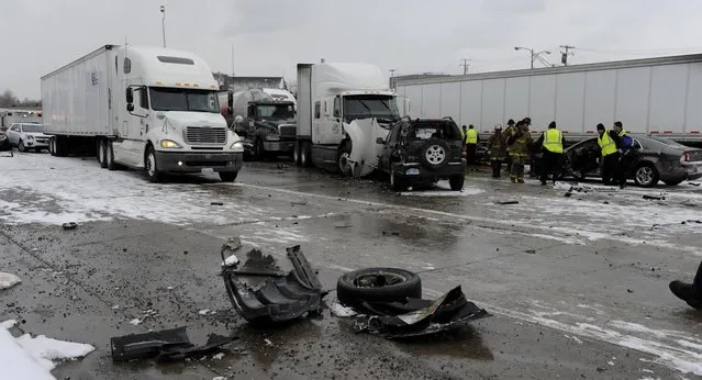 Authorities search a section of multi-vehicle accident on Interstate 75 is shown in Detroit, Thursday, January 31, 2013. Snow squalls and slippery roads led to a series of accidents that left at least three people dead and 20 injured on a mile-long stretch of southbound I-75. More than two dozen vehicles, including tractor-trailers, were involved in the pileups.  (Photo by David Coates/The Detroit News/AP Photo)