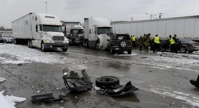 Authorities search a section of multi-vehicle accident on Interstate 75 is shown in Detroit, Thursday, January 31, 2013. Snow squalls and slippery roads led to a series of accidents that left at least three people dead and 20 injured on a mile-long stretch of southbound I-75. More than two dozen vehicles, including tractor-trailers, were involved in the pileups. (Photo by David Coates/The Detroit News/AP Photo)