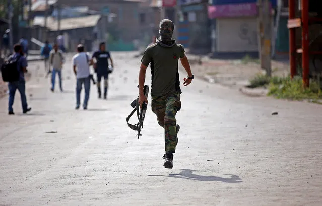 An Indian policeman runs during a protest against the recent killings in Kashmir, in Srinagar September 13, 2016. (Photo by Danish Ismail/Reuters)