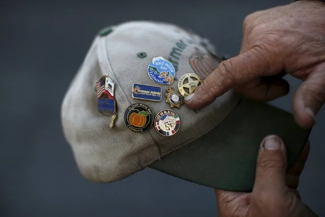 Farmer John, of Half Moon Bay, points to a collection of pins on his hat during the annual Safeway World Championship Pumpkin Weigh-off in Half Moon Bay, California October 12, 2015. (Photo by Stephen Lam/Reuters)