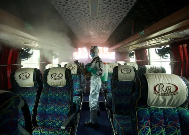 A man sprays disinfectant on a bus as restrictions on long distance public transportation are eased by government following the coronavirus disease (COVID-19) outbreak, in Kathmandu, Nepal on September 17, 2020. (Photo by Navesh Chitrakar/Reuters)