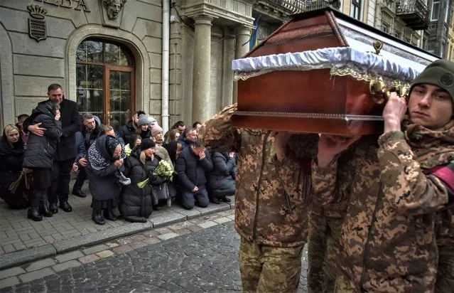People react during a funeral ceremony for Ukrainian servicemen, who were recently killed in fights against Russian troops, amid Russia's attack on Ukraine, in Lviv, Ukraine on January 17, 2023. (Photo by Pavlo Palamarchuk/Reuters)