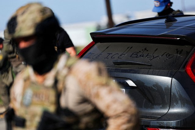 A vehicle with the message “ICE, ICE Baby!” written in the dust on the rear windscreen stands near U.S. federal agents blocking a road leading to an agricultural facility where U.S. federal agents and immigration officers carried out an operation, in Camarillo, California, on July 10, 2025. (Photo by Daniel Cole/Reuters)