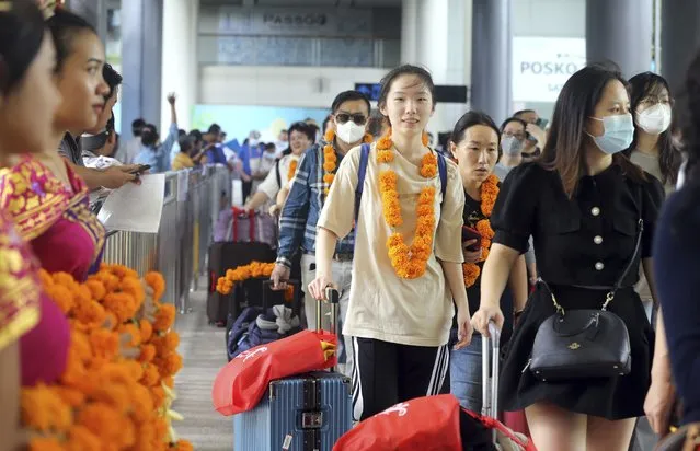 Chinese tourists arrive at Ngurah Rai international airport in Bali, Indonesia on Sunday, January 22, 2023. A direct flight from China landed in Indonesia's resort island of Bali for the first time on Sunday in nearly three years after the route was cancelled due to the pandemic. (Photo by Firdia Lisnawati/AP Photo)