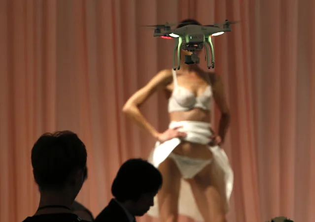 A videographer uses a drone as he takes a video of a model presenting a lingerie creation at the rehearsal for Eve's Temptation collection during China Fashion Week in Beijing, October 26, 2014. (Photo by Kim Kyung-Hoon/Reuters)