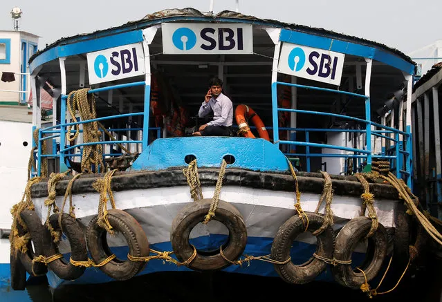 A man speaks on his mobile phone while sitting inside a ferry under the advertisement boards of State Bank of India (SBI), on the bank of the river Ganges in Kolkata, India, February 9, 2018. (Photo by Rupak De Chowdhuri/Reuters)